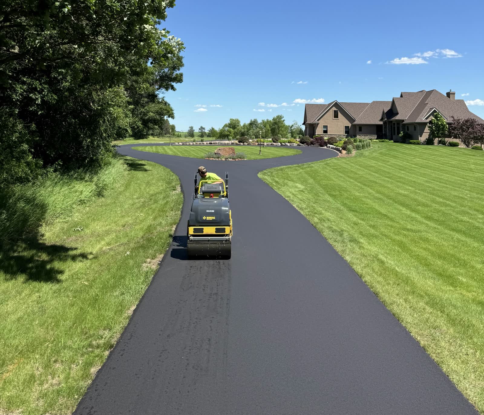 A Team Asphalt roller compacting a fresh asphalt driveway